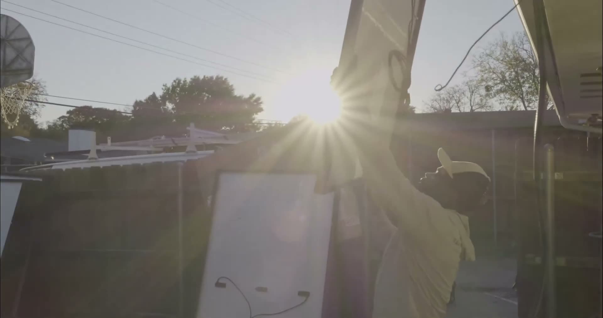 Solar panel lifted into place under bright South Texas sun.